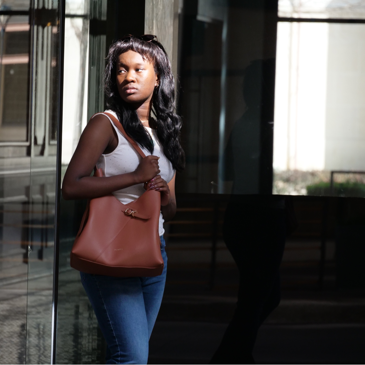 Girl looking back with hangbad on shoulder